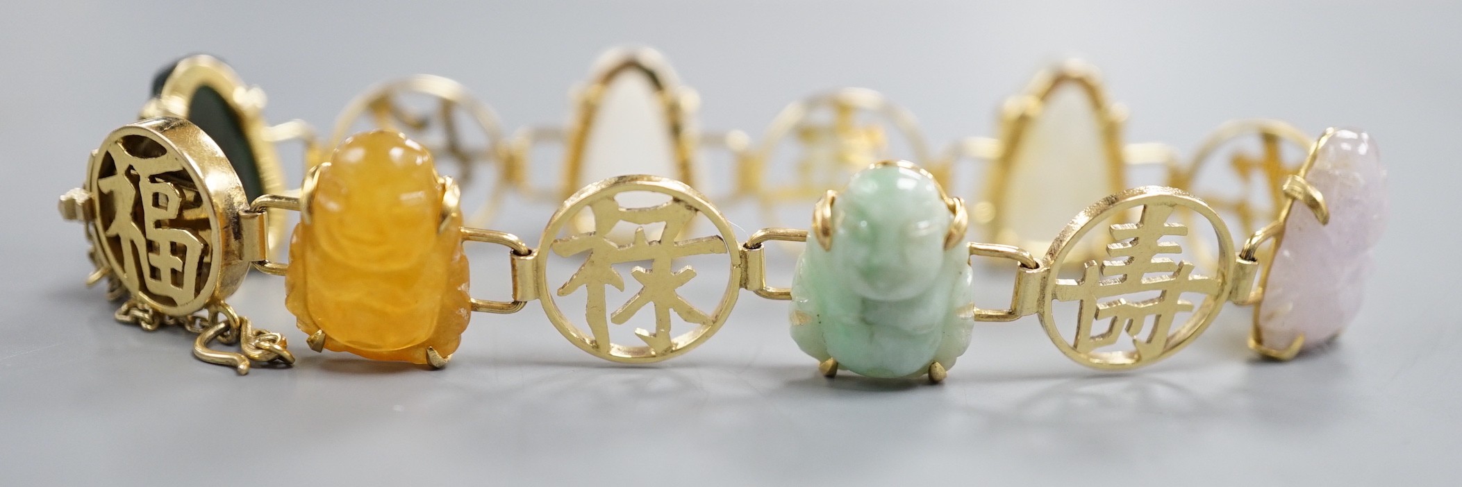 A Chinese 14k yellow metal and hardstone set bracelet, with alternating character and six carved Buddha set links, approx. 17cm, gross weight 17.3 grams.